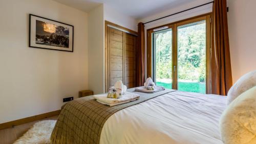 a bedroom with a bed with two towels and a window at Appartement Green in Chamonix