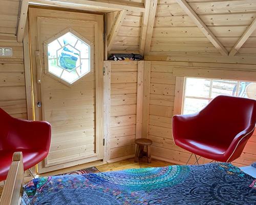 a room with two red chairs and a window at Camping Oase Wahlhausen in Wahlhausen