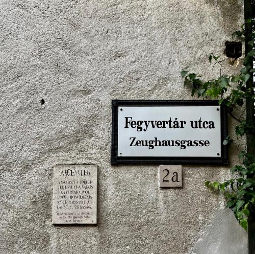 un panneau sur le côté d'un bâtiment dans l'établissement Varga Apartman, à Sopron