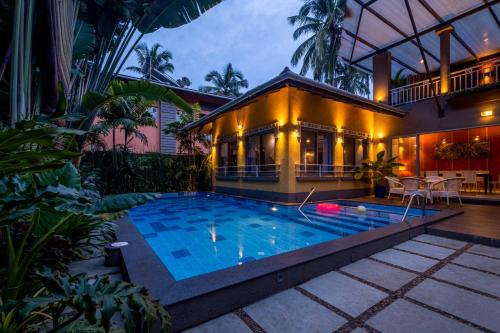 une villa avec une piscine en face d'une maison dans l'établissement Beach 7 mins walk Luxury villa Diva, à Calangute