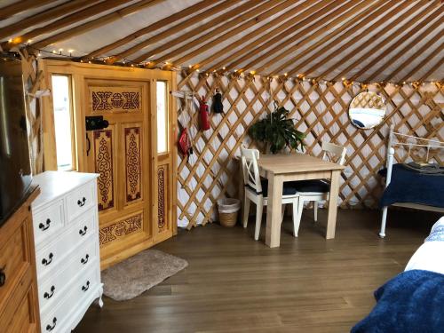 a room with a table and chairs in a yurt at Buzzard Holt Hosting in Buckingham