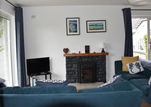 a living room with two blue couches and a fireplace at Cottage on the grounds of Rathmullan House Hotel in Rathmullan