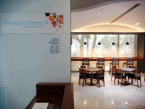a dining room with tables and chairs and a window at Holiday Inn Express Mexico Reforma by IHG in Mexico City