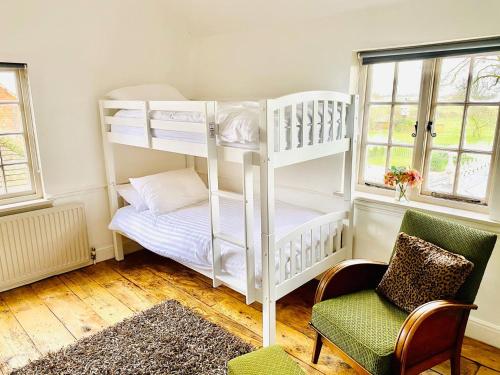 a room with two bunk beds and a chair at Warren Farm Farmhouse nr Oxford in Culham