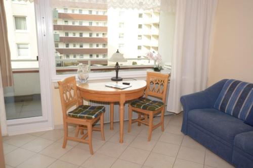 ein Wohnzimmer mit einem Tisch, Stühlen und einem Sofa in der Unterkunft 13-36, sehr Strandnah, im Herzen Westerlands, Westbalkon, 1 Zi in Westerland