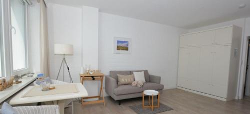 sala de estar con sofá y mesa en Penthouse MEERblick, App 66, en Westerland