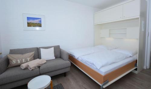 1 dormitorio pequeño con 1 cama y 1 sofá en Penthouse MEERblick, App 66, en Westerland
