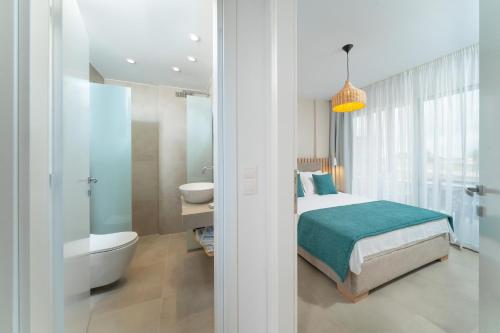 a bedroom with a bed and a tub and a sink at Sentimento Sea Breeze in Skala Prinou