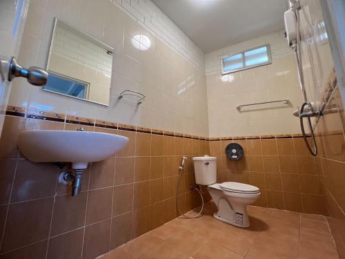 a bathroom with a sink and a toilet at Naisang Hostel in Chumphon