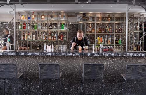 a man sitting at a bar in a room at Nautilux Rethymno by Mage Hotels in Rethymno Town