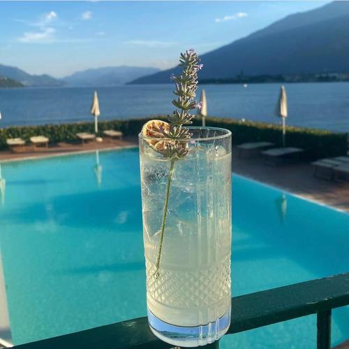 um copo de água com uma planta ao lado de uma piscina em Hotel Regina em Gravedona