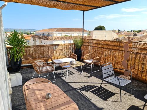 a patio with chairs and tables and an umbrella at Hôtel Le C - Boutique Hôtel in Narbonne