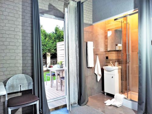 uma pequena casa de banho com um chuveiro e um lavatório. em Pensjonat Pocztówka em Zgierz