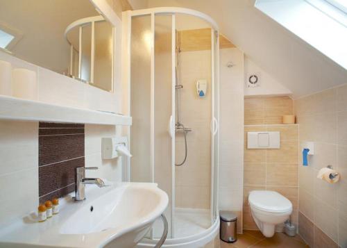 een badkamer met een douche, een wastafel en een toilet bij Pension Kern in Praag