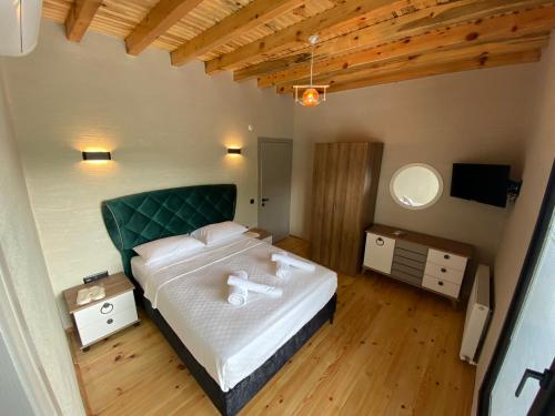 Schlafzimmer mit einem großen Bett mit einem grünen Kopfteil in der Unterkunft ZK Wooden Village in Sapanca