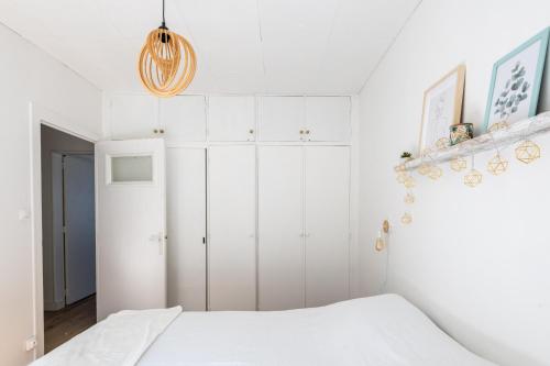 une chambre avec des armoires blanches et un lit dans l'établissement Maison avec véranda lumineuse - 300m de la plage, à La Barre-de-Monts