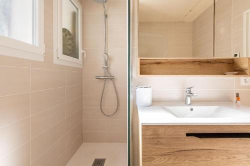 une salle de bain avec un lavabo et une douche dans l'établissement Maison avec véranda lumineuse - 300m de la plage, à La Barre-de-Monts