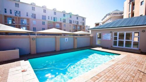 einem großen Pool vor einem Gebäude in der Unterkunft Muizenberg Mountain View Apartment in Kapstadt