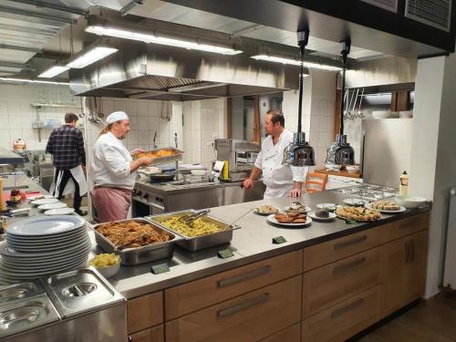 a group of chefs in a kitchen preparing food at Pension a restaurace U sousedů in Strážný