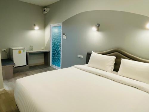 a bedroom with a large white bed and a bathroom at Gallery Design - SHA Extra Plus in Si Sa Ket