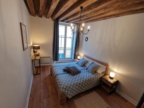 a bedroom with a bed and a large window at Le Saint Jean et son parking privée in Blois