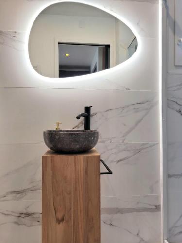 une salle de bain avec un lavabo et un miroir dans l'établissement LA PARENTHÈSE HAVRAISE - Parking privé Plein centre & Très calme, au Havre