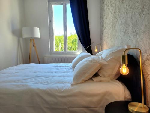 a bedroom with a white bed with a window at LA PARENTHÈSE HAVRAISE - Parking privé Plein centre & Très calme in Le Havre