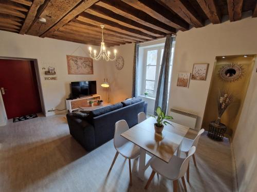 un salon avec un canapé bleu et une table dans l'établissement Le Saint Jean et son parking privée, à Blois