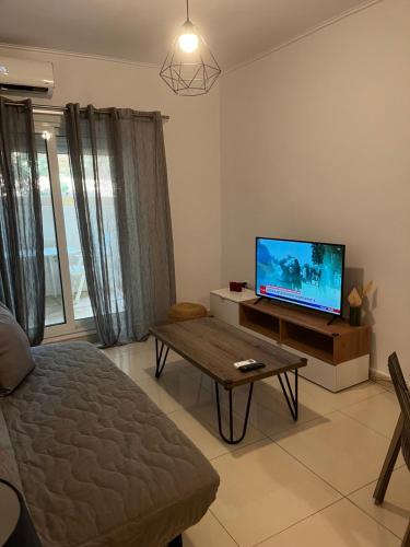 a living room with a tv and a coffee table at ALKYONI in Athens