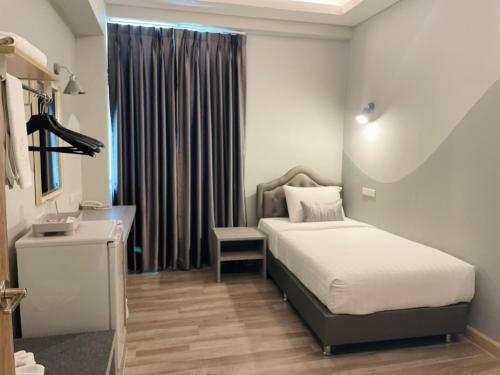 a bedroom with a bed and a desk and a window at Gallery Design - SHA Extra Plus in Si Sa Ket