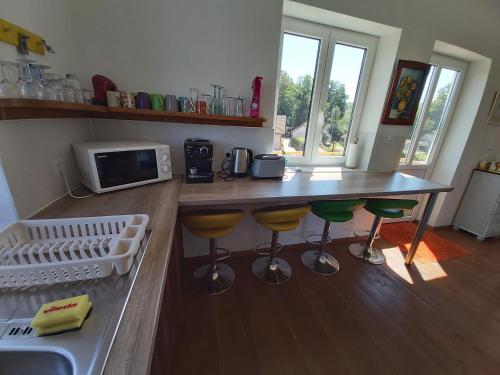 a kitchen with a counter with stools and a microwave at Mill House Apartment and Camping in Ljutomer