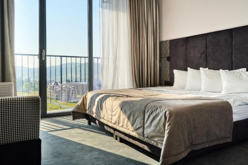 a hotel room with a bed and a large window at Fomich Residence in Bukovel