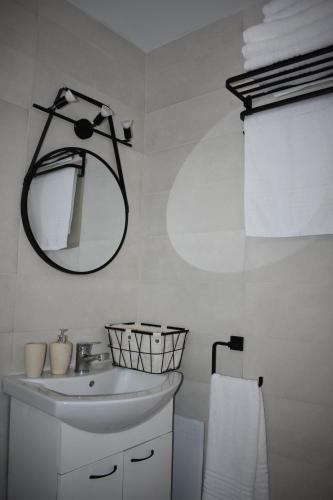 a white bathroom with a sink and a mirror at Stegna Rita's apartment in Archangelos