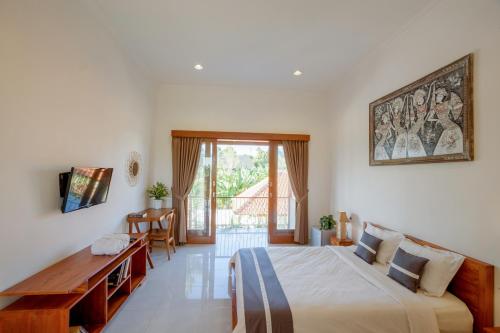 une chambre avec un lit, un bureau et une fenêtre dans l'établissement Eden Guest House Canggu, à Canggu