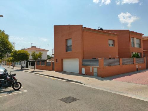 una motocicleta estacionada en una calle frente a un edificio en Chalet amplio con Jardín y zona barbacoa. en Reus