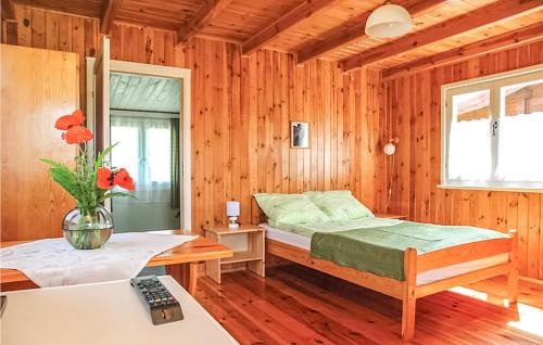 a bedroom with a bed in a wooden room at Amazing Home In Ustronie Morskie With 1 Bedrooms And Wifi in Ustronie Morskie