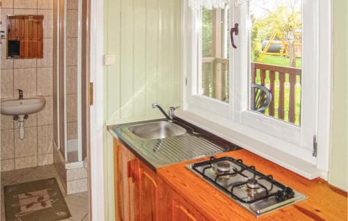 a kitchen with a sink next to a window at Gorgeous Home In Ustronie Morskie With Kitchenette in Ustronie Morskie