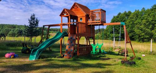a playground with a tree house and a slide at Siedlisko Owink in Swornegacie
