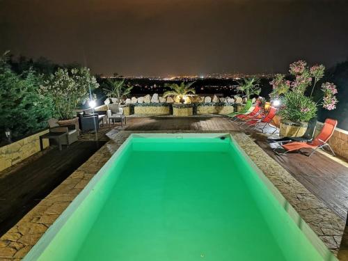 a green swimming pool in a backyard at night at Villa Somlyó in Fót