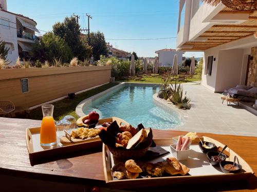 a tray of food on a table next to a swimming pool at Olvion Luxury Living in Kallithea Halkidikis