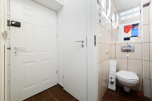 een badkamer met een witte deur en een toilet bij Downtown Buda Homes Relax in Boedapest
