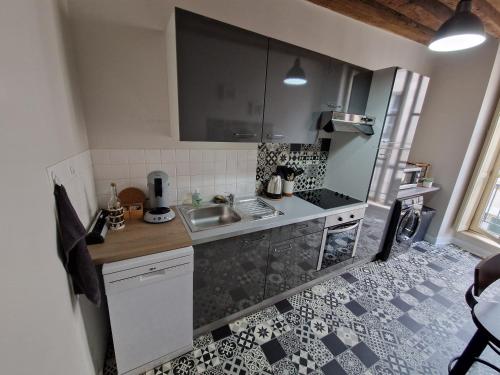 una pequeña cocina con fregadero y nevera. en Le Saint Jean et son parking privée en Blois