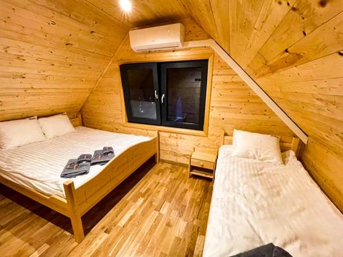 a bedroom with two beds in a wooden cabin at Leśne Zacisze Iwkowa in Iwkowa