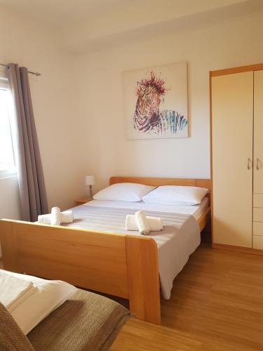um quarto com uma cama e um quadro na parede em Two Bedroom Apartment ''Sunrise'' em Pakoštane