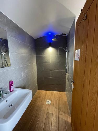 a bathroom with a sink and a shower with a blue light at Mount View Overnight Accommodation in Penzance