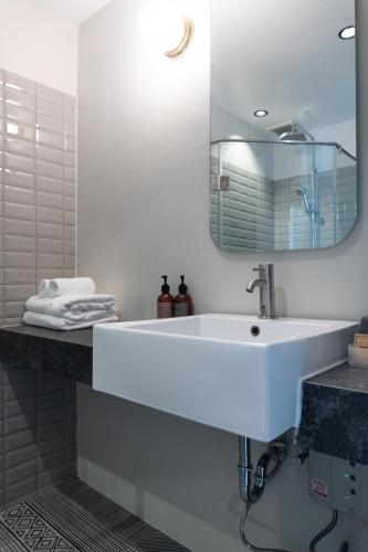 a bathroom with a white sink and a mirror at karaarom hotel in Bangkok
