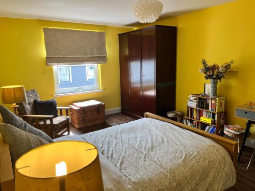 a bedroom with a bed and a chair and a window at St John's Town of Dalry Glentress Apartment 1 in Dalry