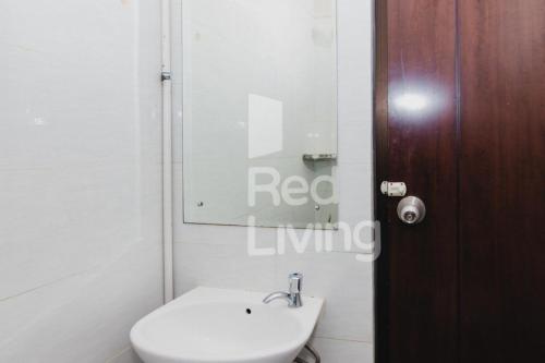 uma casa de banho com um WC branco e um lavatório. em Columbus Residence J10 near RSUD Karawang Mitra RedDoorz em Karawang
