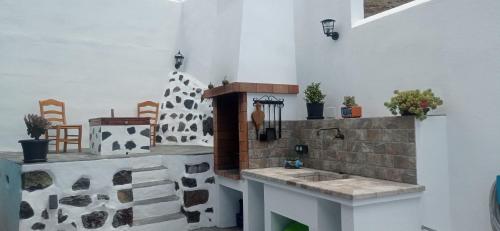 eine Küche mit einem Waschbecken in einem Zimmer mit Stühlen in der Unterkunft Casa marroquina in Las Indias