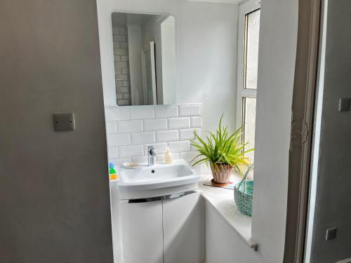 a white bathroom with a sink and a mirror at St John's Town of Dalry Glentress Apartment 1 in Dalry